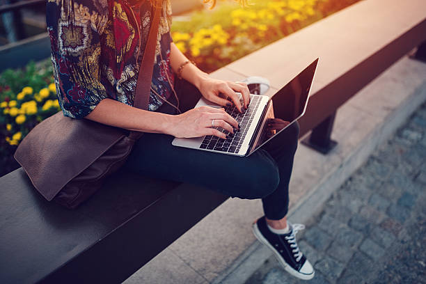 Young woman working from computer in the city park