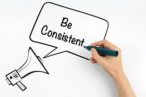 Photo of Be Consistent. Megaphone and text on a white background.