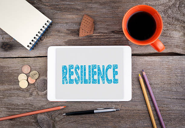 Resilience. Text on tablet device on a wooden table