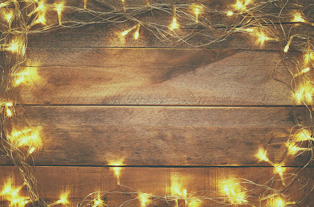 istock Christmas tree garland lights on wooden rustic background 637169270