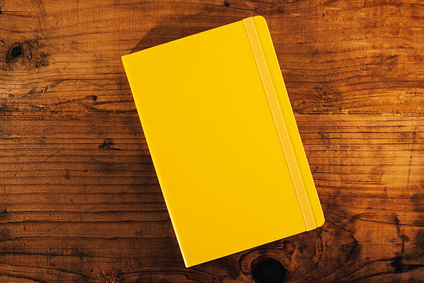 istock Yellow notebook on office desk, top view 637169460