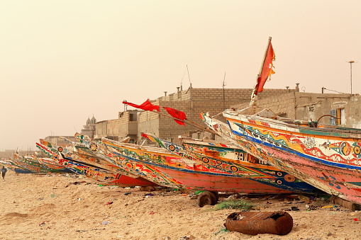 St.-Louis, Senegal-April 19, 2014: The Guet Ndar fishing quarter on the Langue de Barbarie sandstrip is linked to St.-Louis island by Mustapha Malik Gaye bridge. Here nearly all men are fishermen sailing in wooden fishing pirogues-the women wait for them on the beach and take charge of the fish.