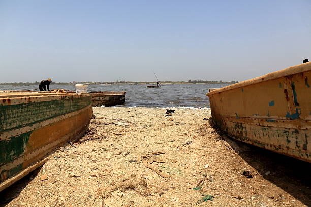 łodzie na jeziorze retba-lac rose. cap vert półwysep-senegal. 3135 - rowboat fishing africa fishing industry zdjęcia i obrazy z banku zdjęć