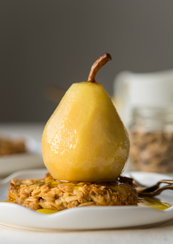 Poached pear in saffron sugar syrup over an oat cookie