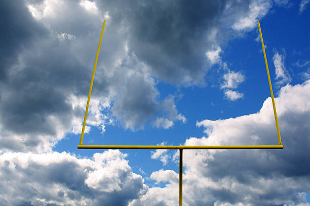 bramka na boisku piłkarskim z chmurami i żółtym słupkiem - aspirations goal post american football sky zdjęcia i obrazy z banku zdjęć