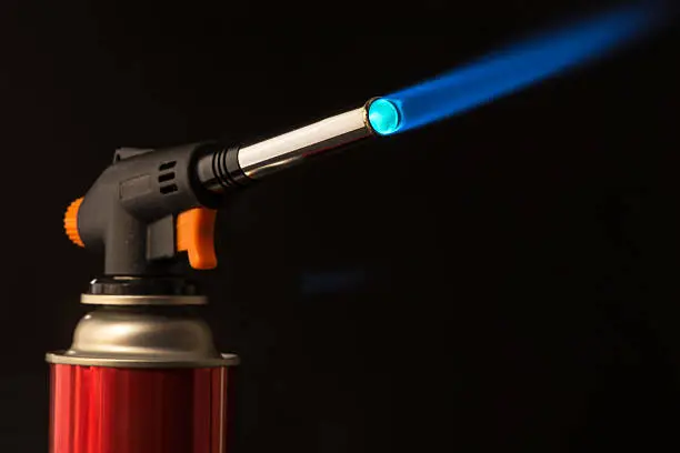 gas burner - burning tool with a blue flame. low key