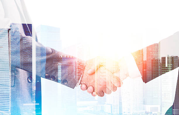 istock Businessmen shaking hands against large city panorama 637182610