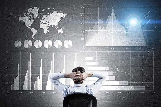 istock Businessman with hands behind head studying graphs on blackboard 637182680
