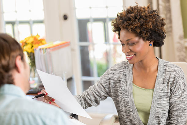 istock Businesswoman discusses document with colleague 637183310