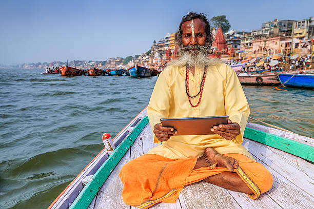 istock Sadhu using digital tablet in boat, Holy Ganges River, Varanasi 637183378