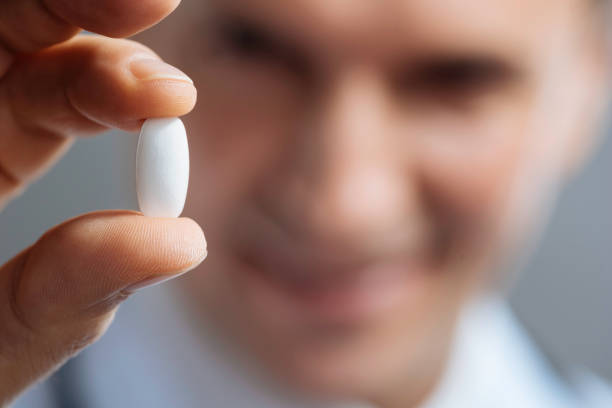 istock Close up of doctors hands holding a pill 637184440