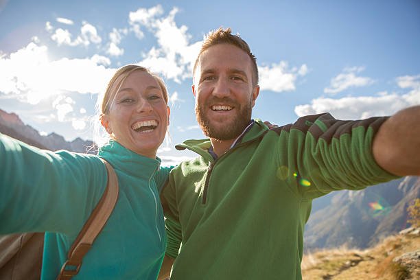 istock Young couple hiking take selfie on mountain top 637185126