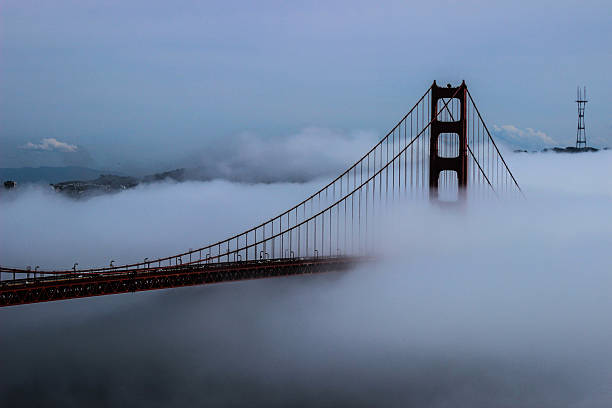 nebbia che inghiottisce il golden gate bridge - bridge golden gate bridge cloud san francisco bay foto e immagini stock