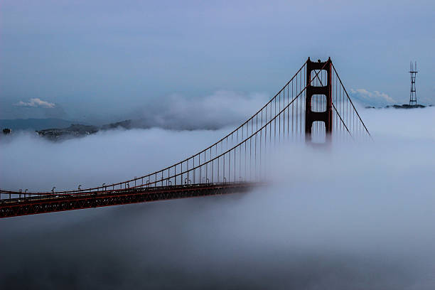 fog swallowing the golden gate bridge - bridge golden gate bridge cloud san francisco bay imagens e fotografias de stock