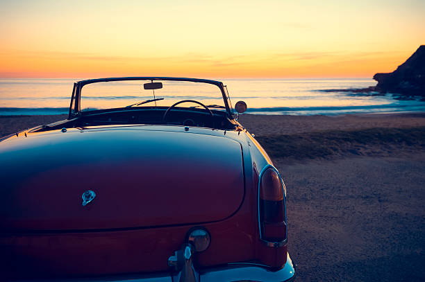 転換には、夕暮れのビーチ、または sunrise - road trip collectors car sports car convertible ストックフォトと画像