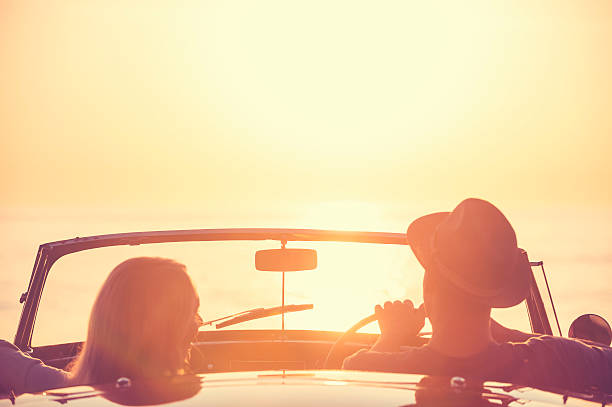 istock Couple watching the sunset in a convertible car 637186582