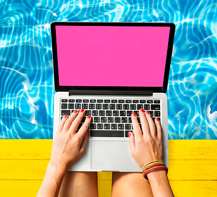 Manos de mujeres escribiendo Macbook concepto junto a la piscina photo