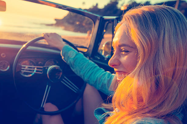 istock Woman driving a convertible at the beach 637188146