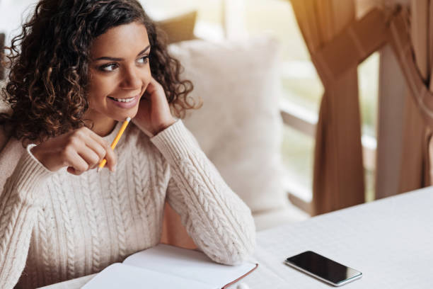 istock Delighted African American woman writing her novel 637190328