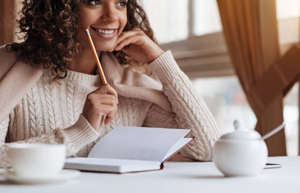 istock Positive African American woman making notes in the cafe 637190394
