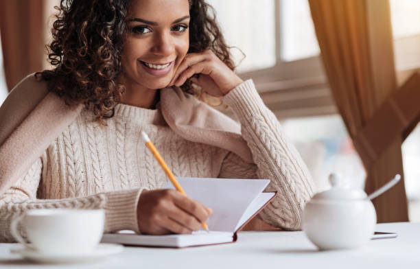 istock Cute pleasant African American woman making notes in the notebook 637190418