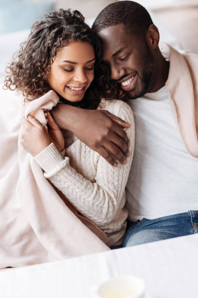 istock Delighted young African American couple sitting and hugging 637191554