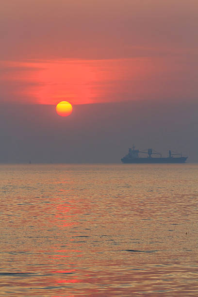 istock Sunset time with ship at the sea 637193500