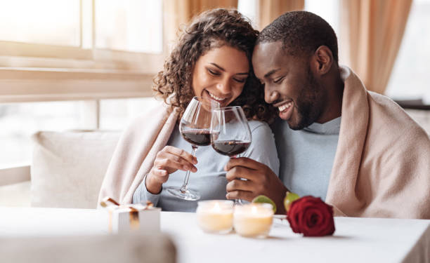 joyeux couple afro-américain buvant du vin dans le restaurant - flower single flower black white photos et images de collection