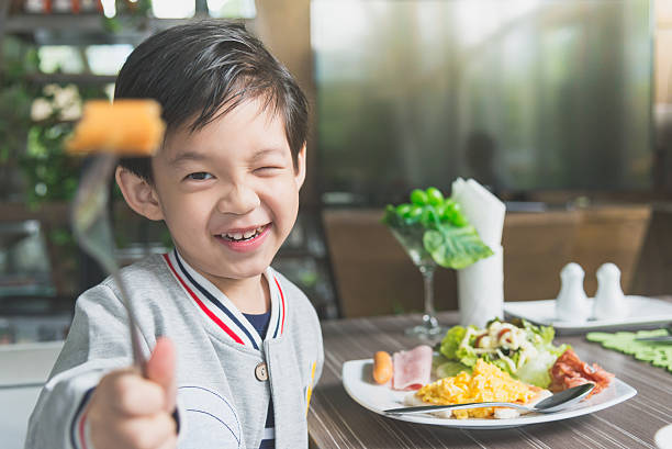 asian child eating breakfast - breakfast family child healthy eating imagens e fotografias de stock