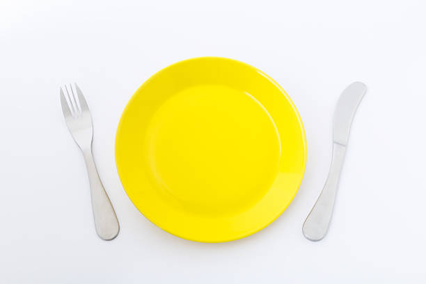 istock Yellow dish, fork and knife on white background. 637197540