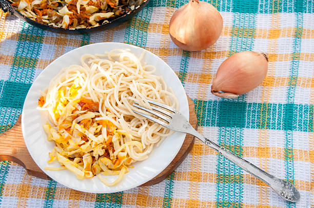 istock Plate of spaghetti with stewed cabbage on a green towel 637199548