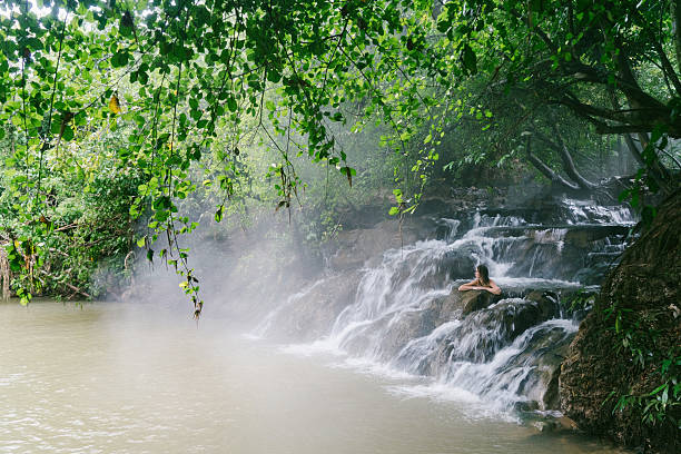 Woman bathing in hot spring waterfall