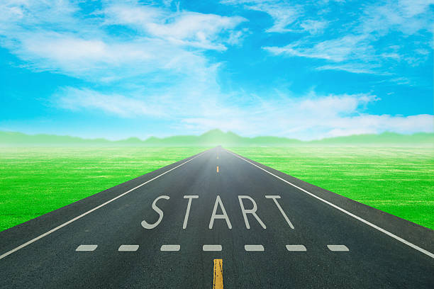 istock road through the green field with sign start on asphalt 637201960