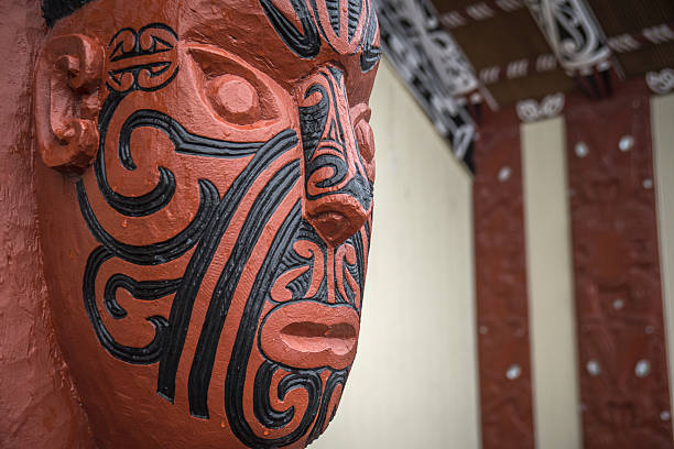 Vancouver, Canada - July 24, 2016: One of nine totem poles at Hallelujah point in Stanley Park. Portrait of two pastel colored wooden masks on arch. Circular format, flame pattern.