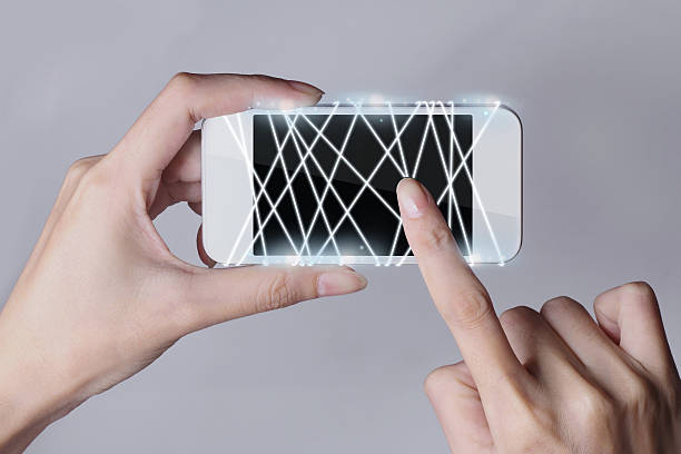 istock Optical fiber emitting white light with smartphone and hands 637205102