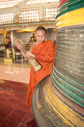 Buddhist hitting the yangon bell in Myanmar