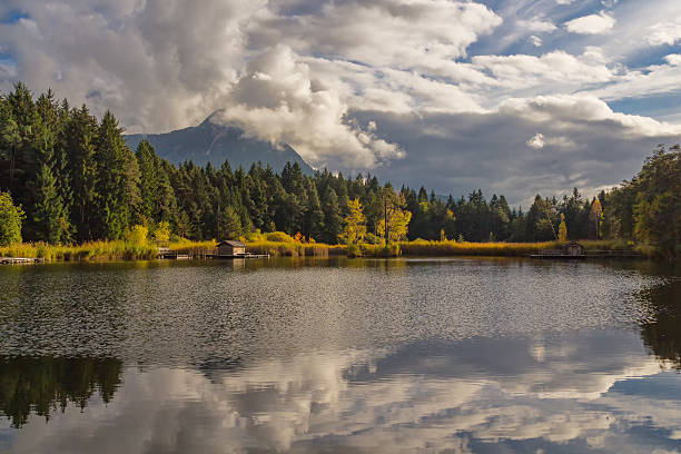 istock autumn colorful dolomites mountain peaks with blue sky reflecting in 637211594