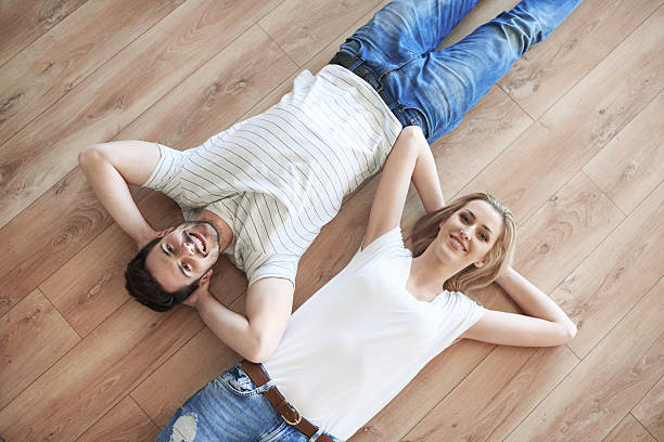 istock Couple with hands behind head laying on the floor 637212084