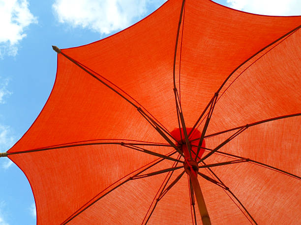 istock One vibrant orange colored sunshade against vivid blue sky 637214414