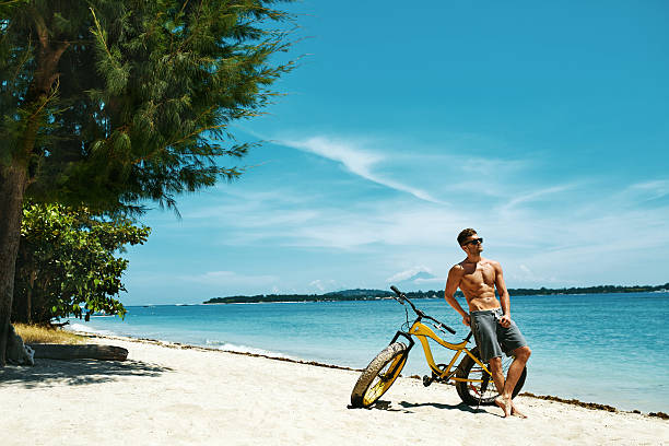 istock Handsome Man With Bike Sun Tanning On Beach. Summer Vacation. 637215020