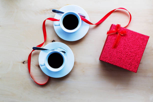 istock Cups with coffee, gift box decorated by ribbon on table. 637217594