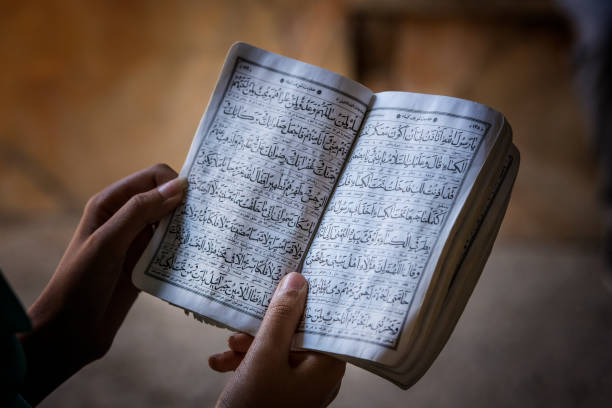 mãos femininas segurando um livro do alcorão - cultura iraniana oriente médio - fotografias e filmes do acervo