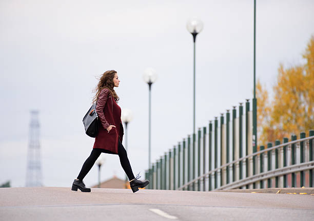 istock Woman crossing road on bridge. It's fall 637219294