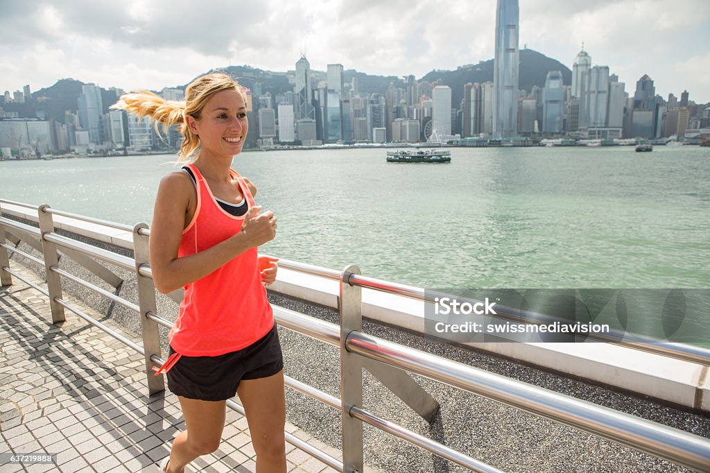 One young woman joggin in Hong Kong City Running - One young woman running in Hong Kong. Female athlete fitness athlete jogging training living healthy lifestyle on Tsim Sha Tsui Promenade and Avenue of Stars in Victoria Harbour, Kowloon. Jogging Stock Photo