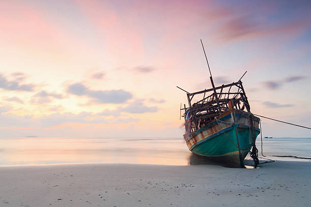 istock abandoned boat at beach in twilight 637220192