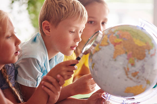 Children using magnifying glass in Geography
