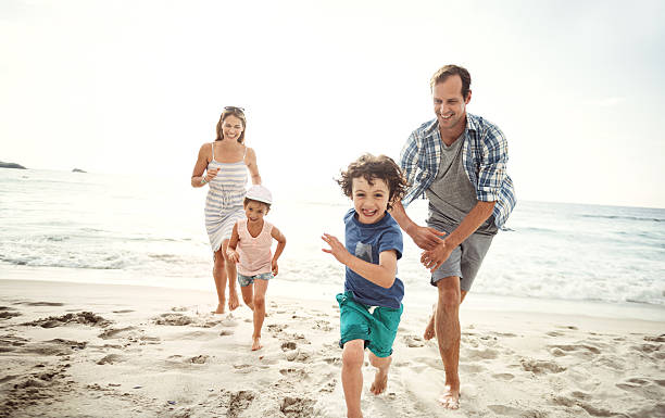 I'm gonna get you! Shot of a happy young family running on the beach beach play stock pictures, royalty-free photos & images