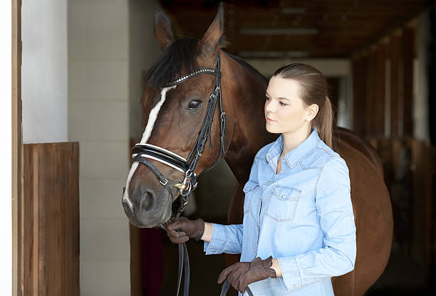 istock Woman and her horse at stable 637225662