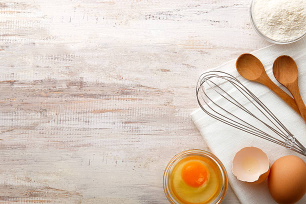 Baking ingredients flat lay on wooden background with copy space