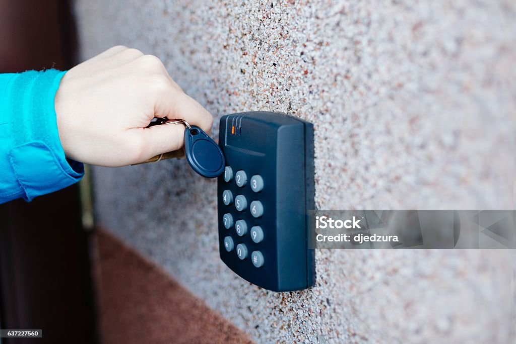 Woman opening house doors Woman opening house doors with electronic remote transmitter Accessibility Stock Photo